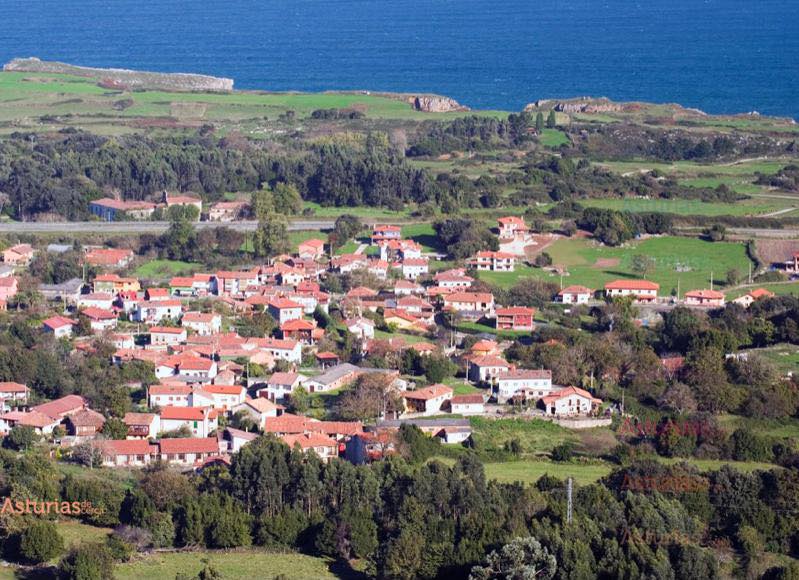 ALT:"Vista panorámica de Hontoria, una encantadora aldea rural en Llanes, Asturias, rodeada de verdes praderas y montañas."
