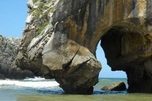 alt="Arco de roca natural en la Playa de Cuevas del Mar, una de las formaciones más impresionantes de la costa de Llanes
