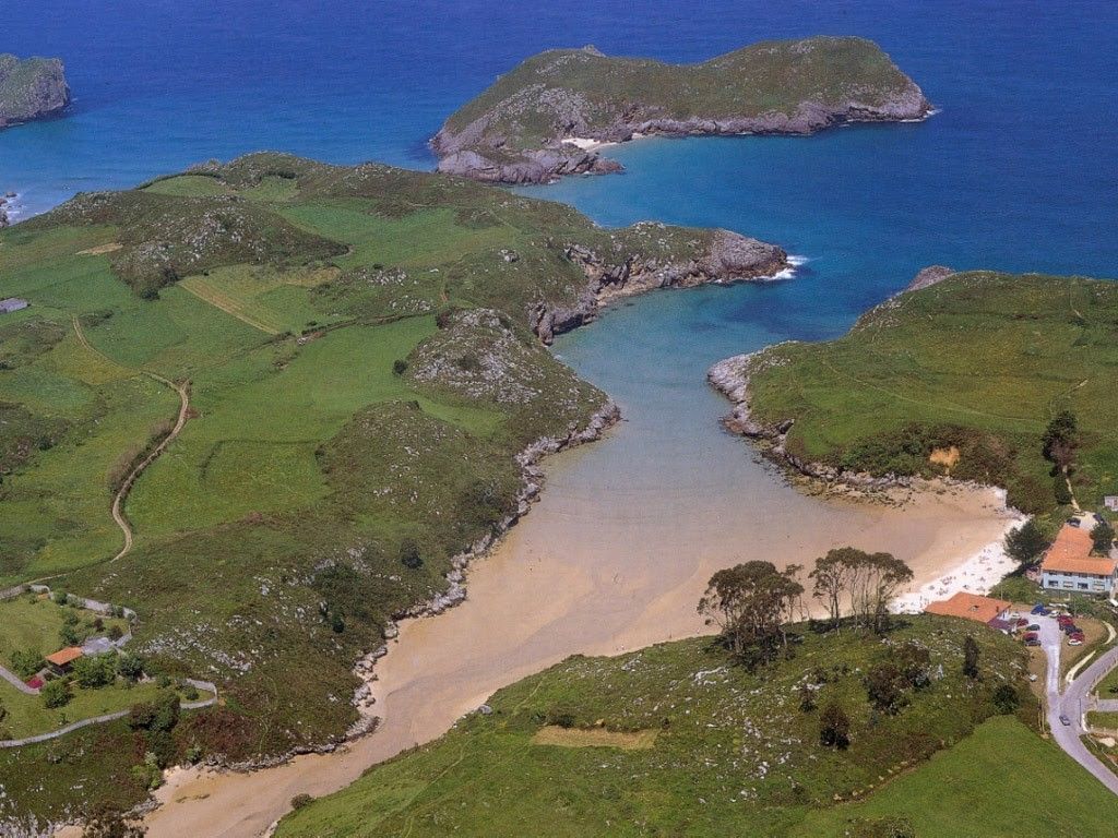 alt="Vista de la Playa de Poo de Llanes, un pintoresco pueblo de Asturias con playas cercanas, ideal para disfrutar de Casas Rurales de Llanes."