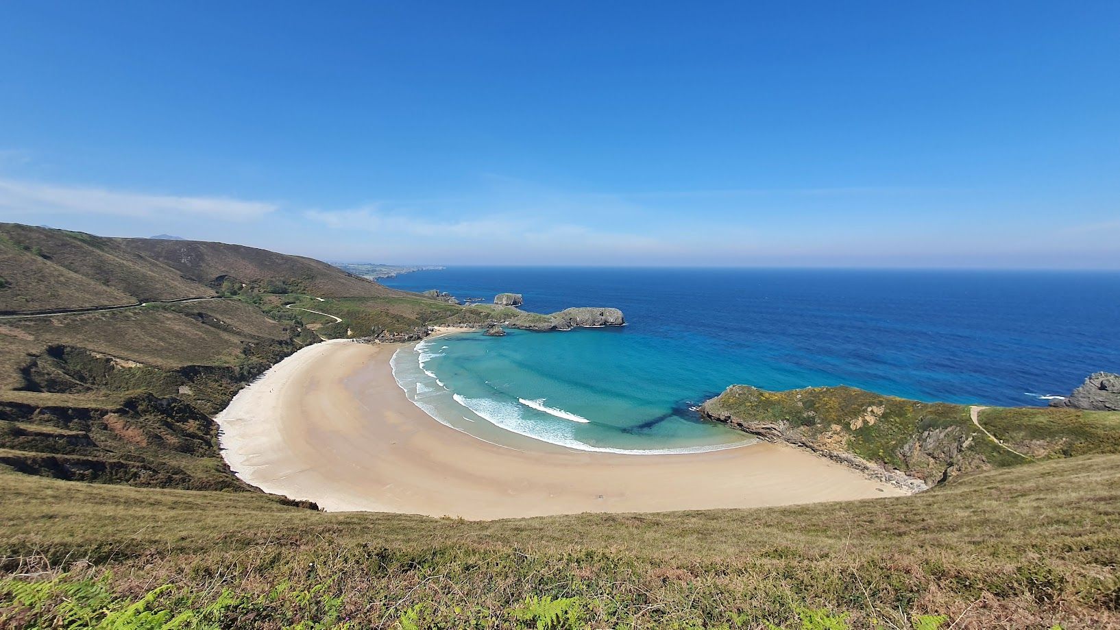 alt="Playa de Torimbia en Niembro, Llanes, aguas tranquilas y entorno natural preservado"