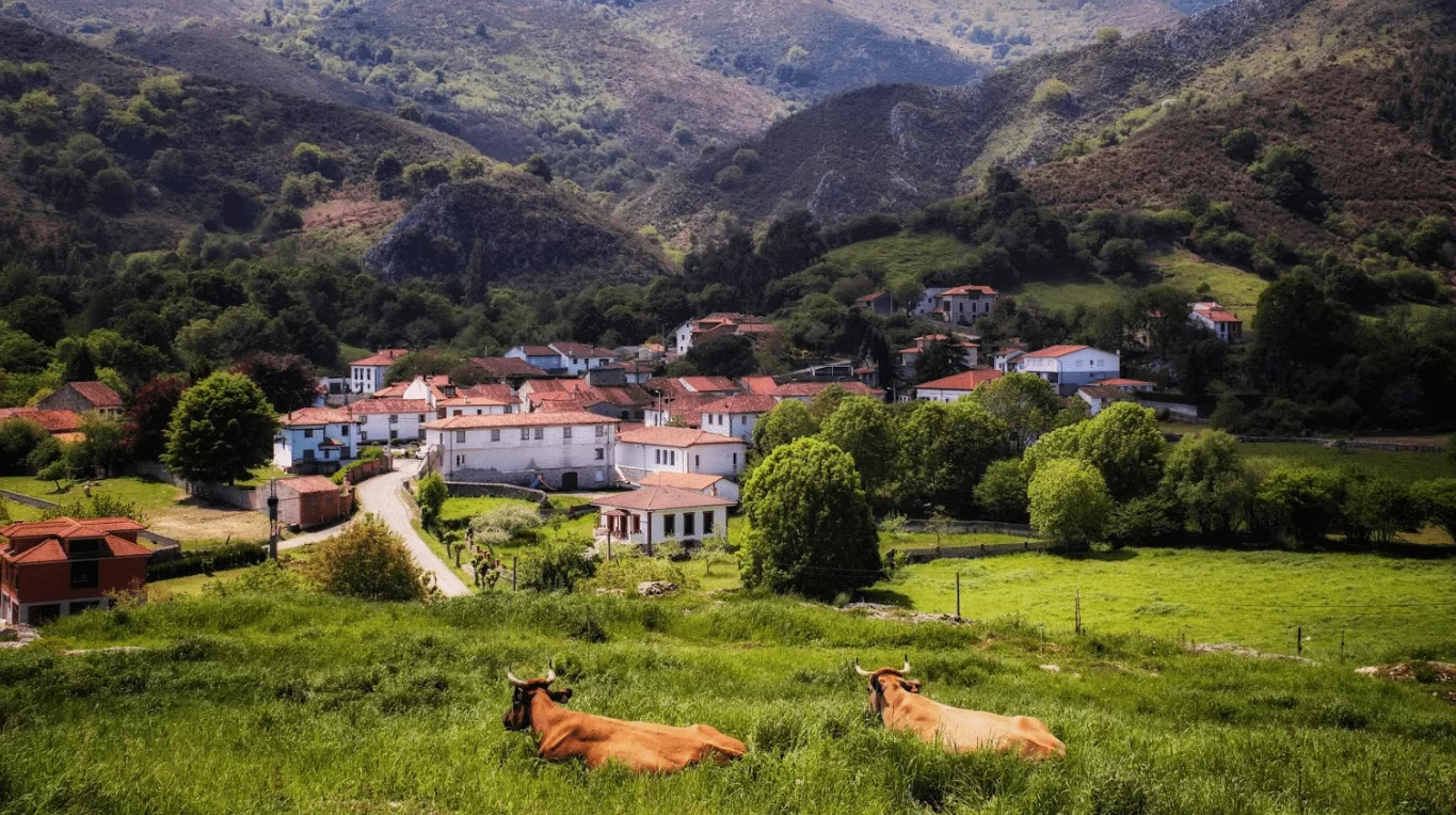 alt="Vista de La Borbolla, un tranquilo pueblo de Llanes en Asturias, rodeado de naturaleza verde y cercano a Casas Rurales de Llanes."