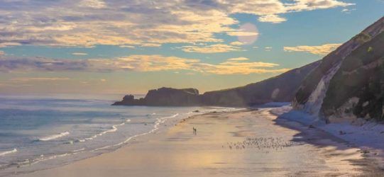 alt="Atardecer en la Playa de San Antolín, con vistas a los acantilados y el mar Cantábrico.