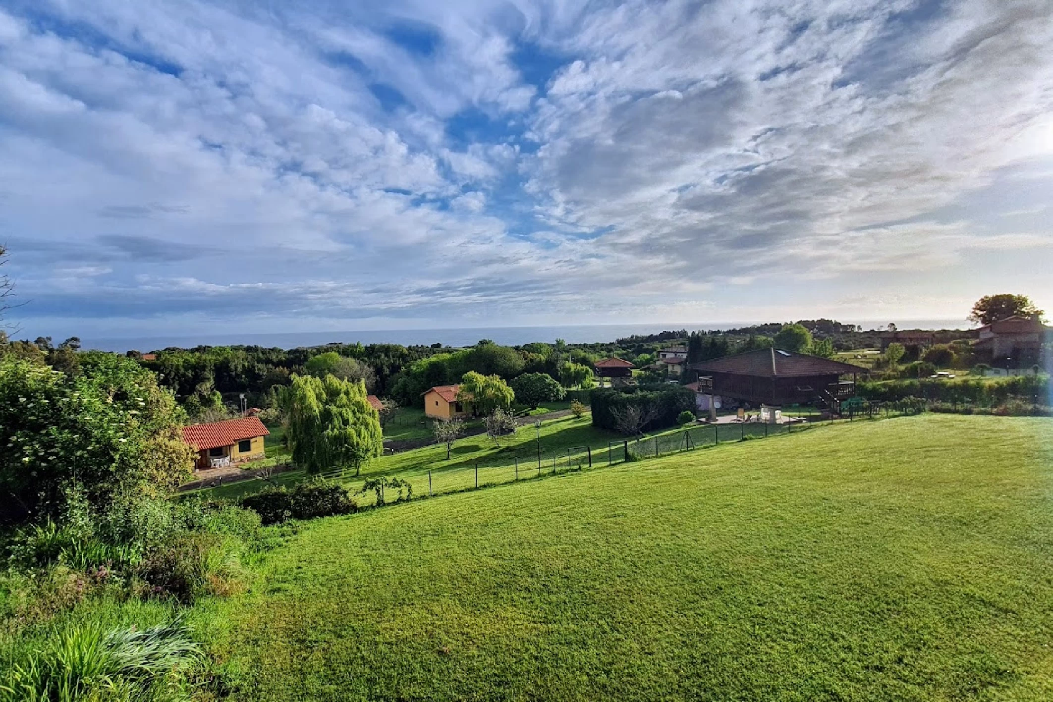 alt="Panorámica de Ovio con entorno de Casas Rurales de Llanes y vistas al mar Cantábrico"
