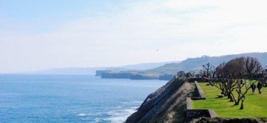 alt="Vista panorámica del Paseo de San Pedro en Llanes con el mar Cantábrico al fondo, paseo recomendado en la Guía Turística Llanes"
