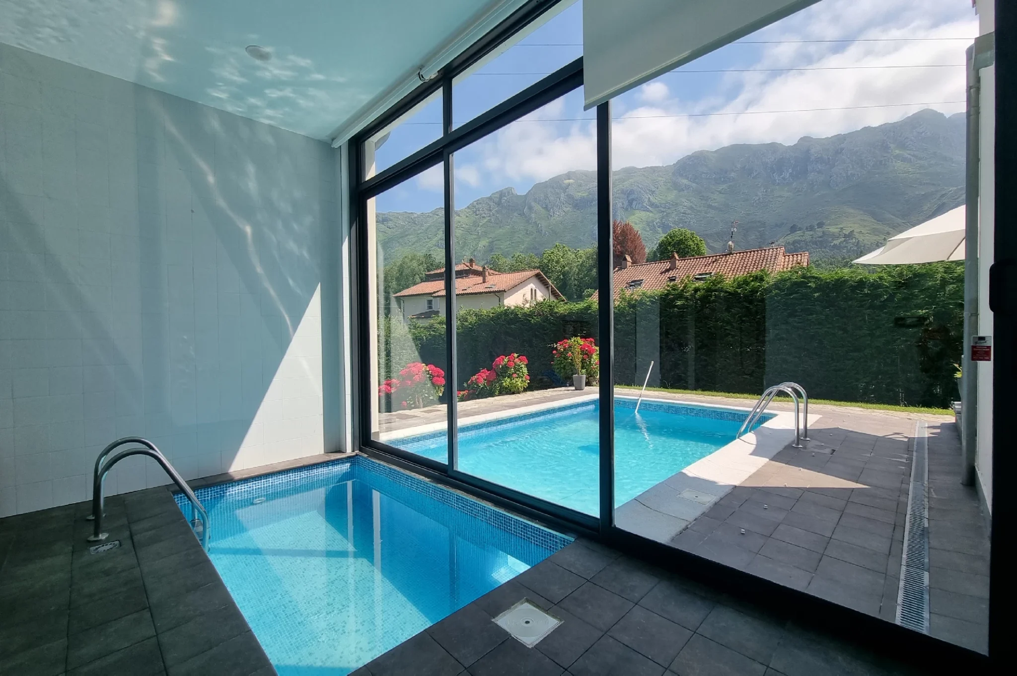 alt="Vista de la piscina privada en el interior y exterior de Villa La Talima, ubicada en Llanes"